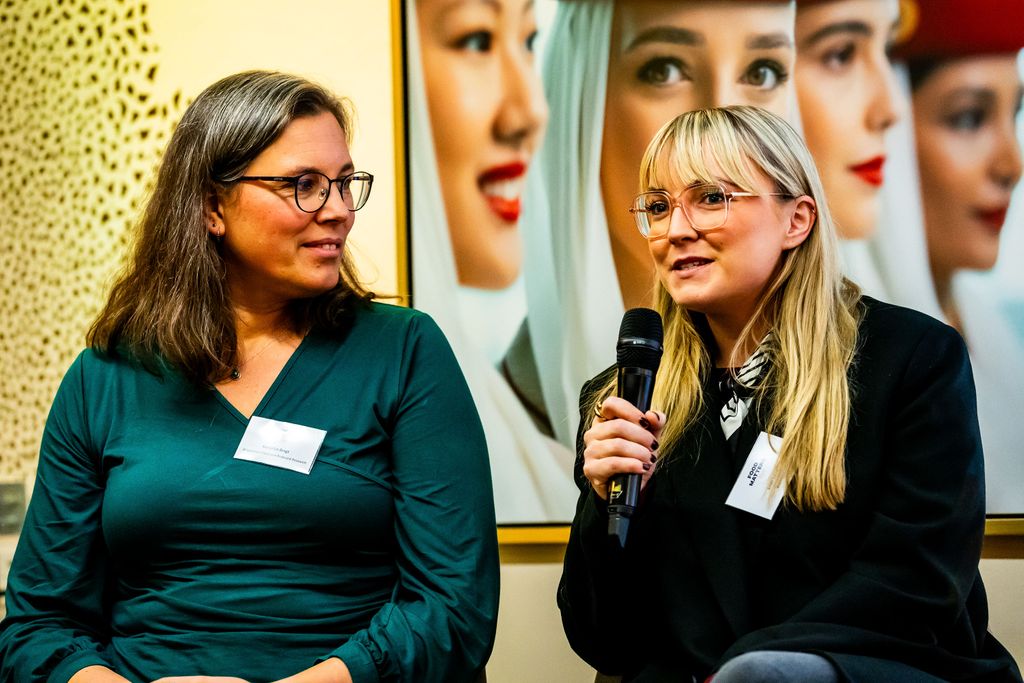 two women speaking on a panel