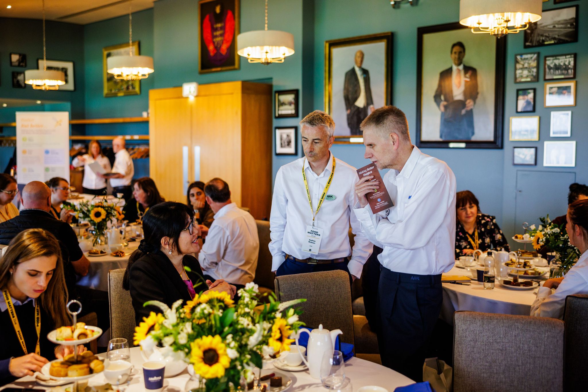 men standing talking to a woman sitting