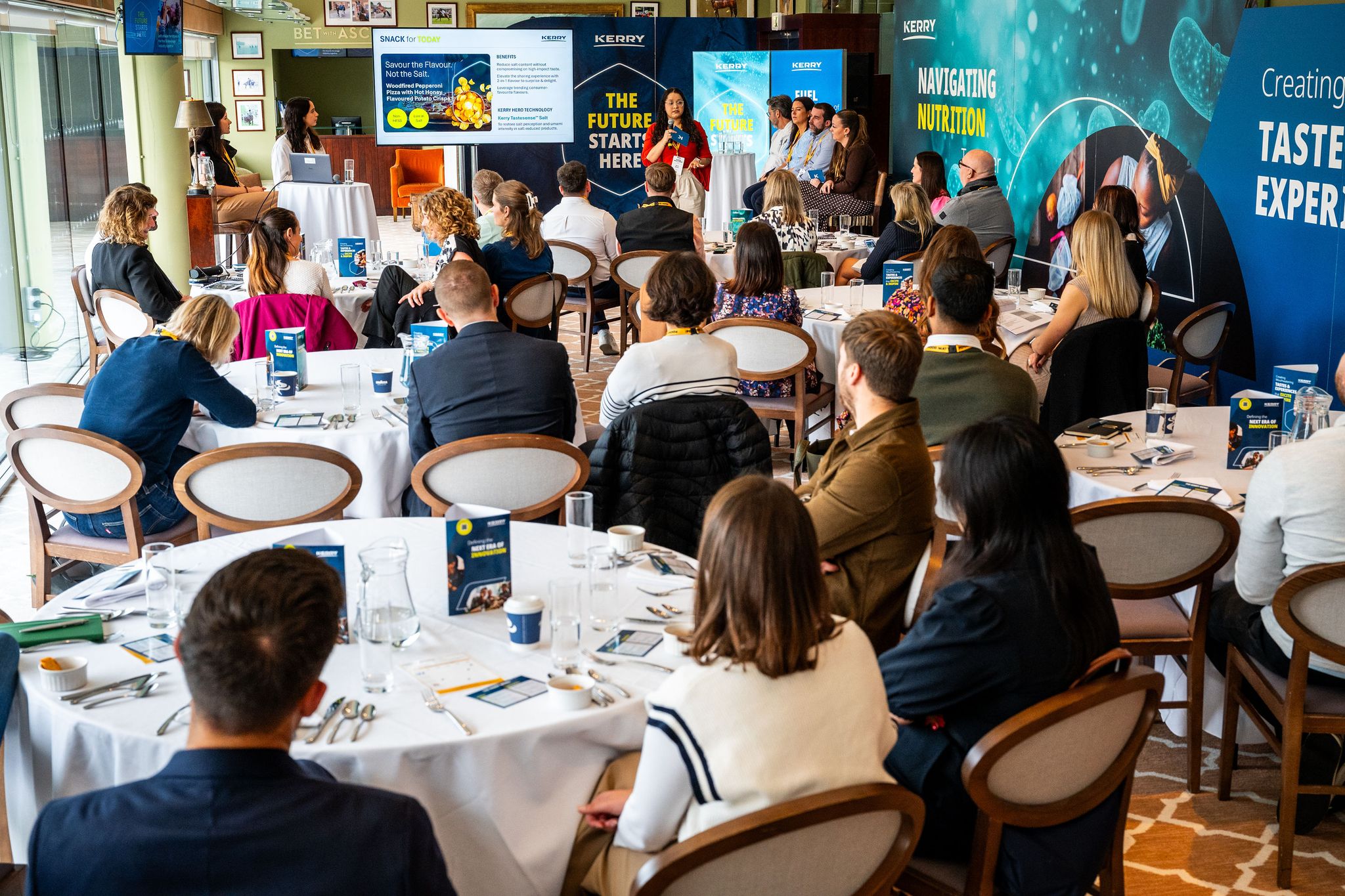 people sat at tables watching a presentation
