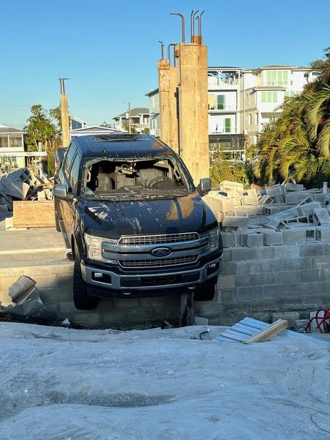 dusty black Ford 4x4 with broken in windscreen, looking broken down