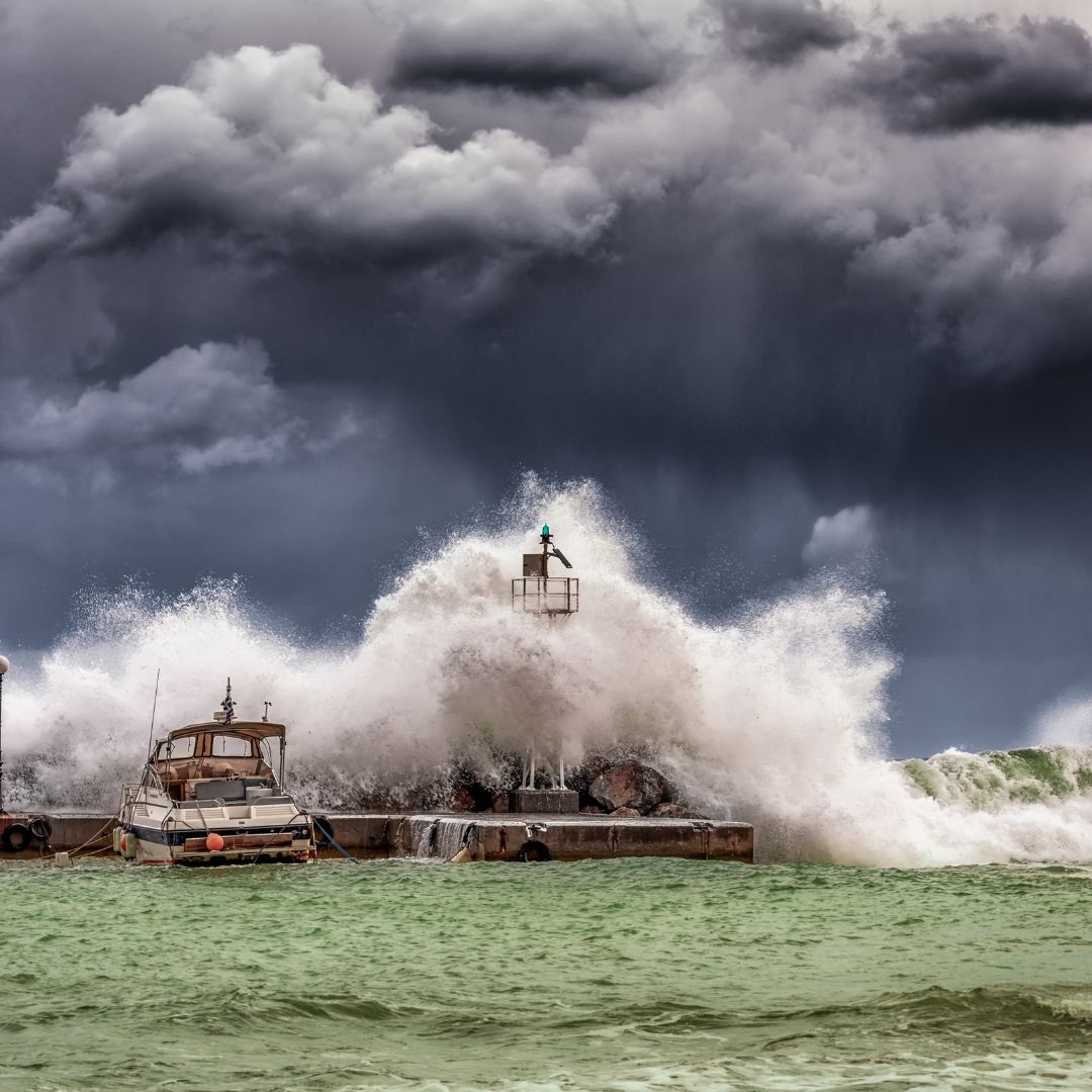 A wave hitting a pier in a storm