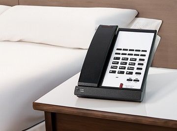 Business-style hotel landline phone on a white desk with abstract wave background