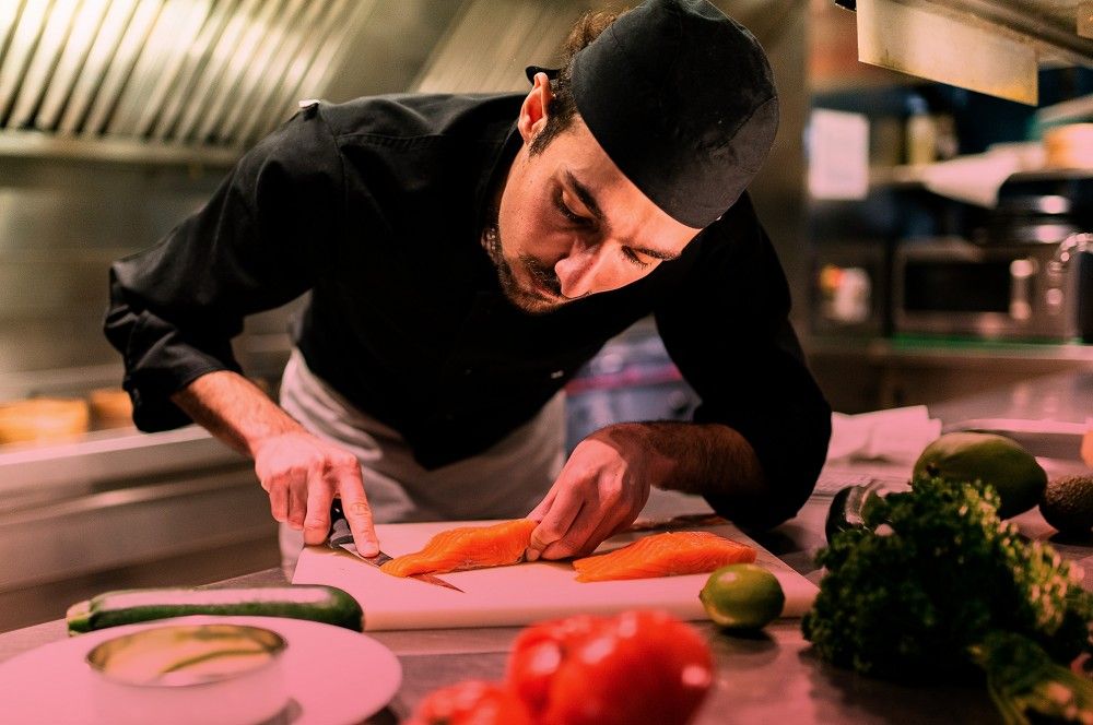 A chef preparing fresh salmon – Brigad helps hospitality teams meet demand with skilled freelance professionals.