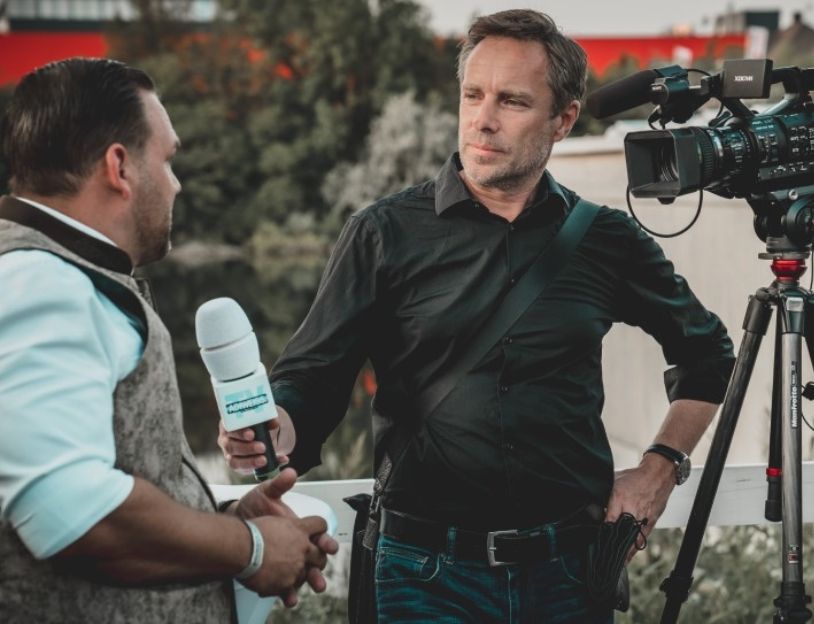 Reporter interviewing in front of a camera
