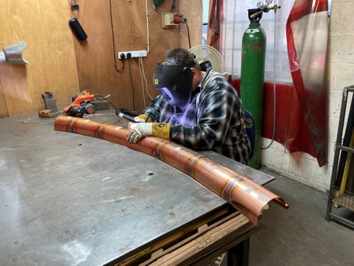 Curved copper guttering for a tree house