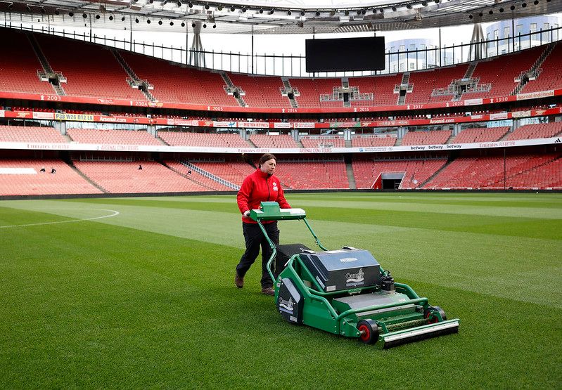 Woman mowing sports ground