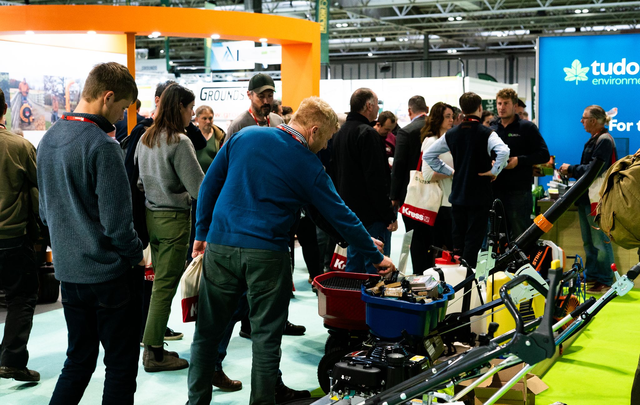 attendees looking at machine at exhibitor stand