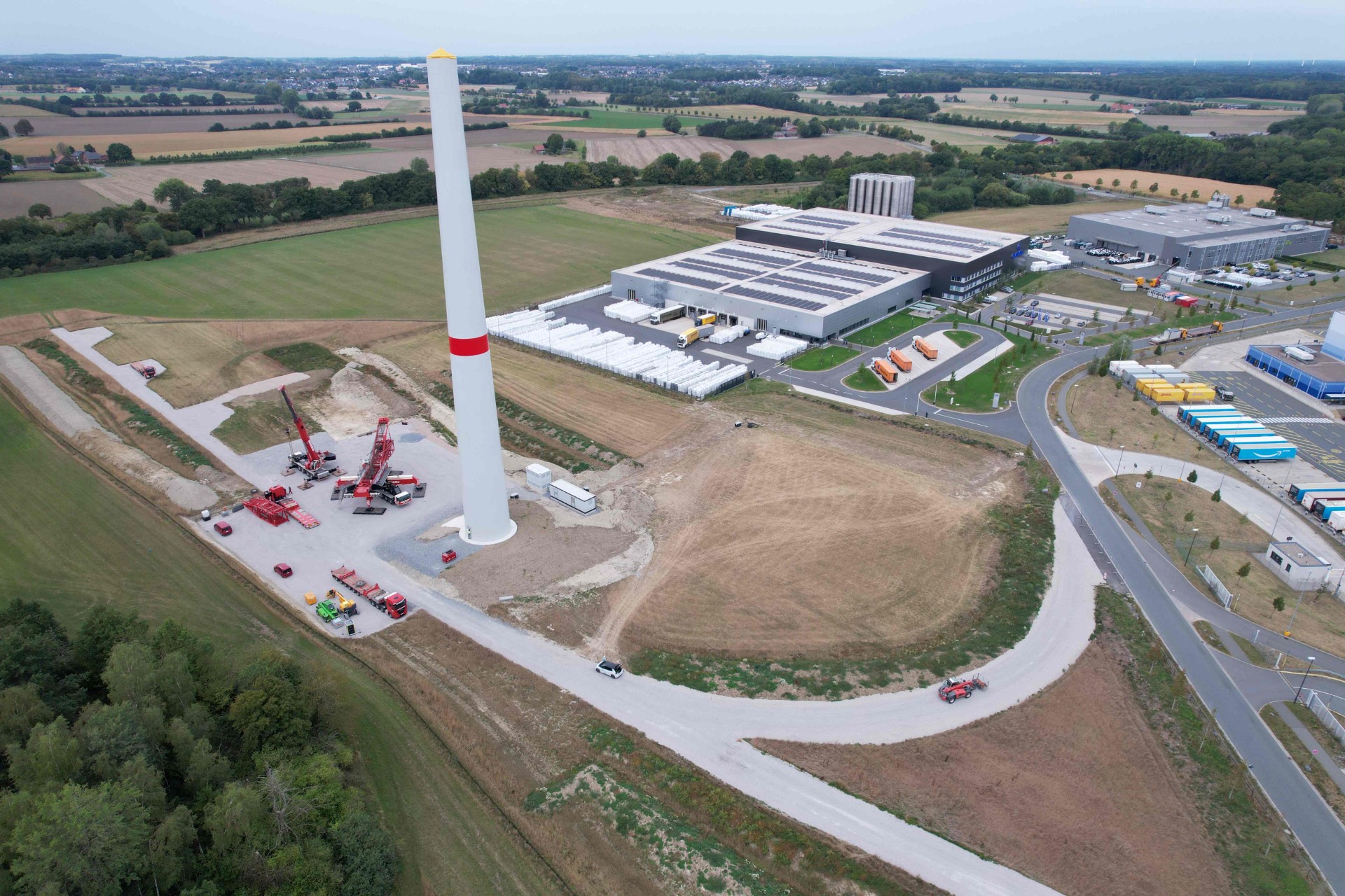 The lower section of the wind turbine currently under construction – made of concrete segments – has already been erected at the Oelde site, only a few metres from the Craemer injection moulding plant. Photo: Craemer Group