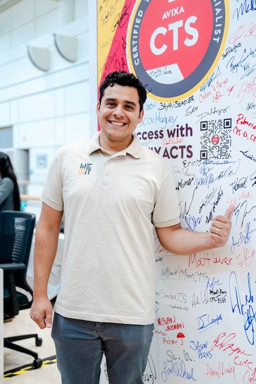 CTS holder standing in front of a signed CTS wall