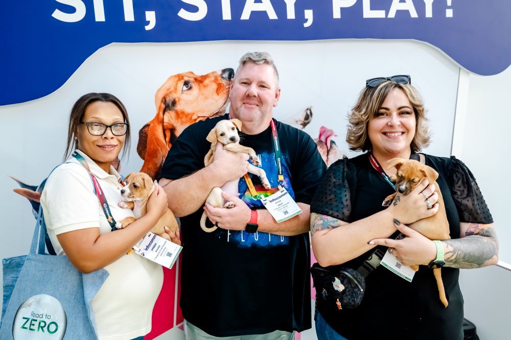 InfoComm attendees holding puppies at the puppy playground