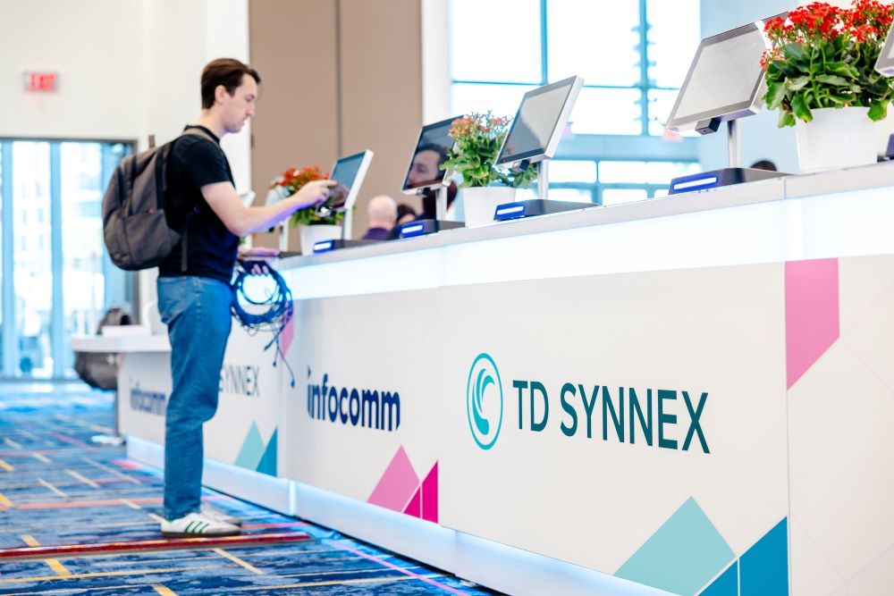 InfoComm attendee picks up his bag at the registration counter