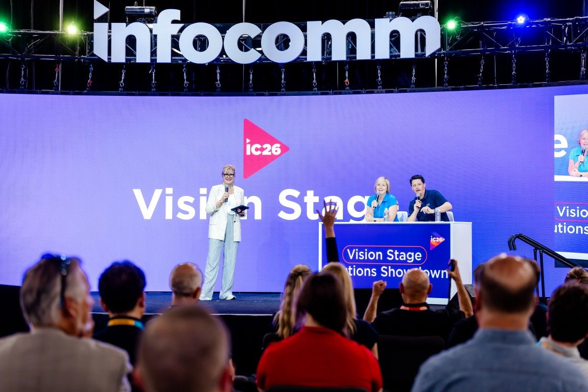 A speaker at InfoComm smiles from a podium 