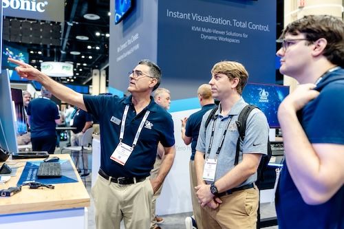 InfoComm exhibitor shows an attendee their products in their booth