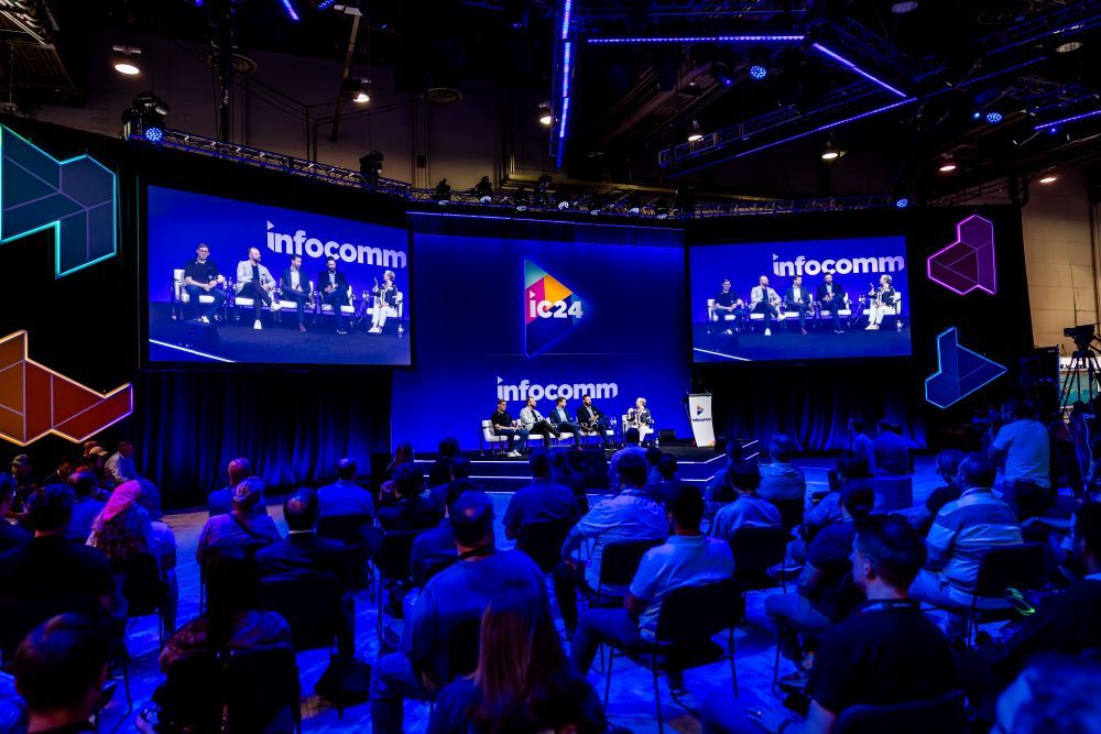 A large crowd sits around the Technology Innovation Stage at InfoComm