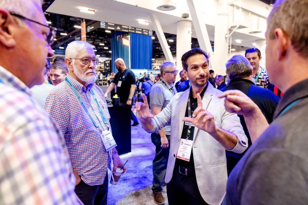 Exhibitor talking to attendees in their booth