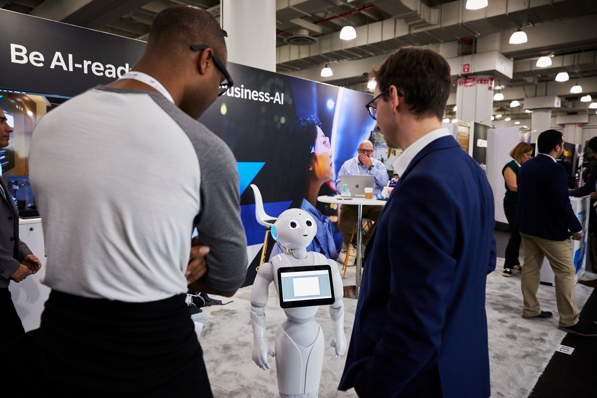 Two attendees at The AI Summit New York looking at a robot