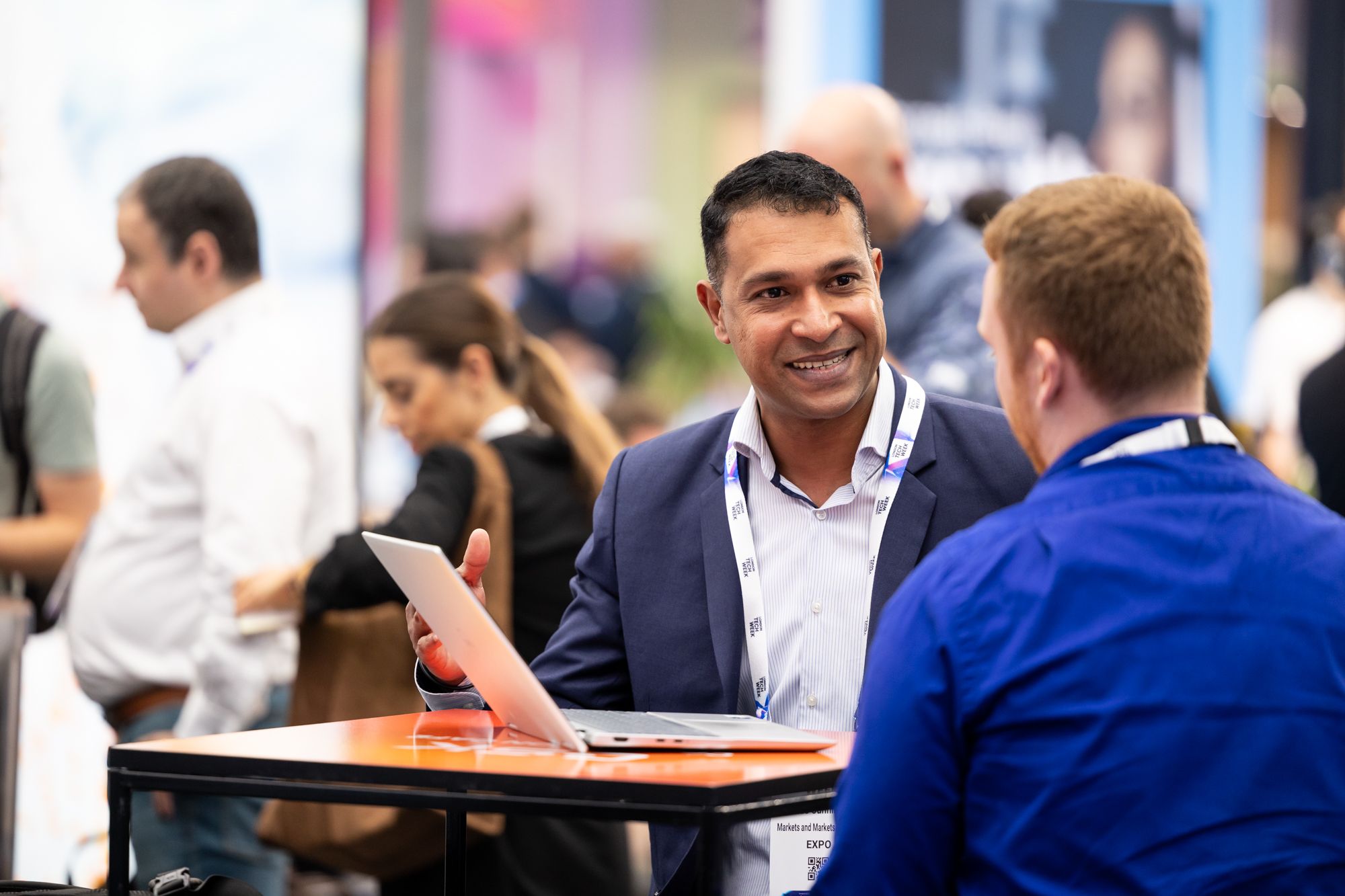 Two men networking and chatting onsite at London Tech Week 2025