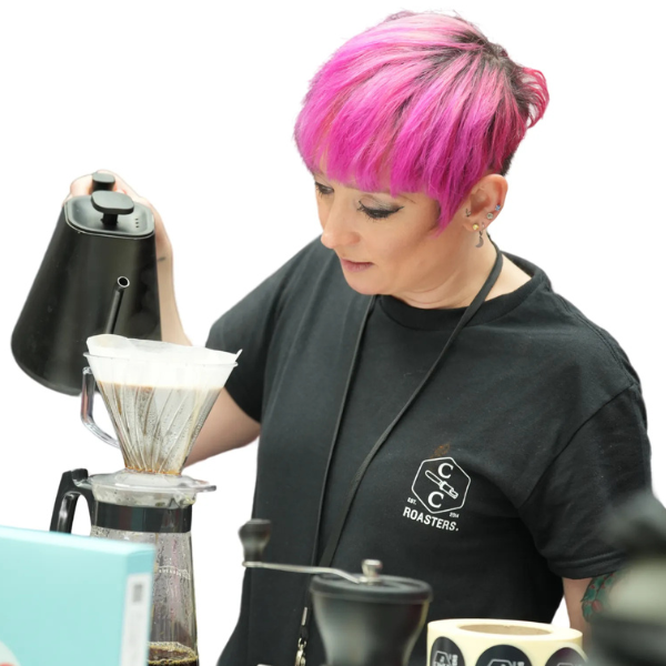Barista pouring hot water into coffee