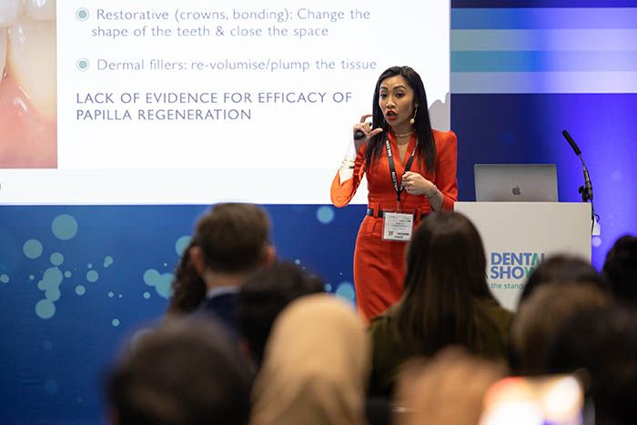 Dental professionals talk at dental show on innovations in cosmetic dentistry and facial aesthetics.