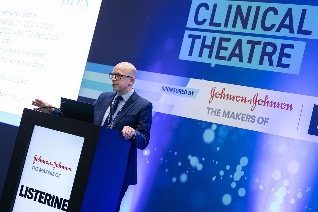 A dental professional presents at a dentistry conference on the latest restorative techniques.