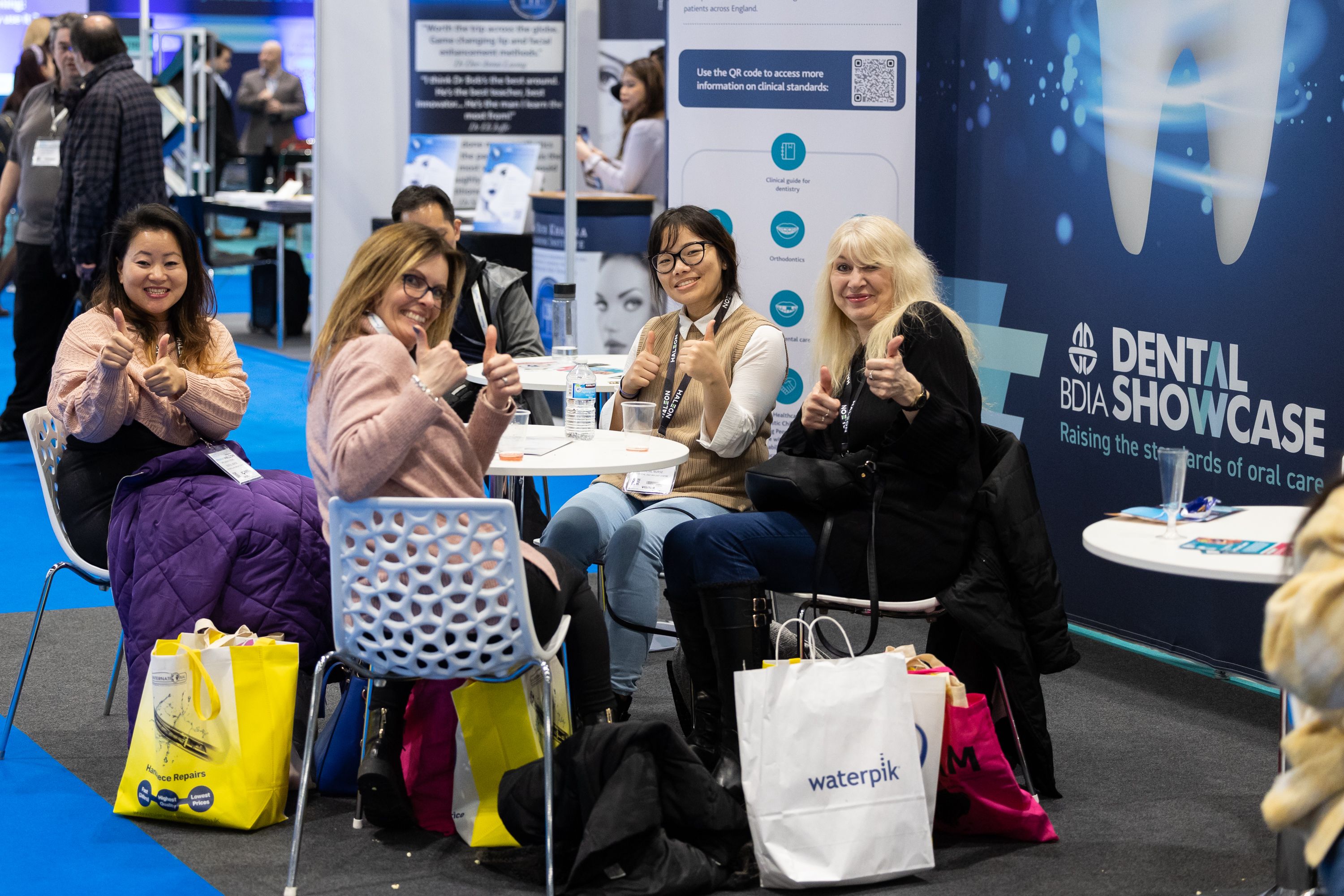 A group of visitors sitting round a table and looking happy
