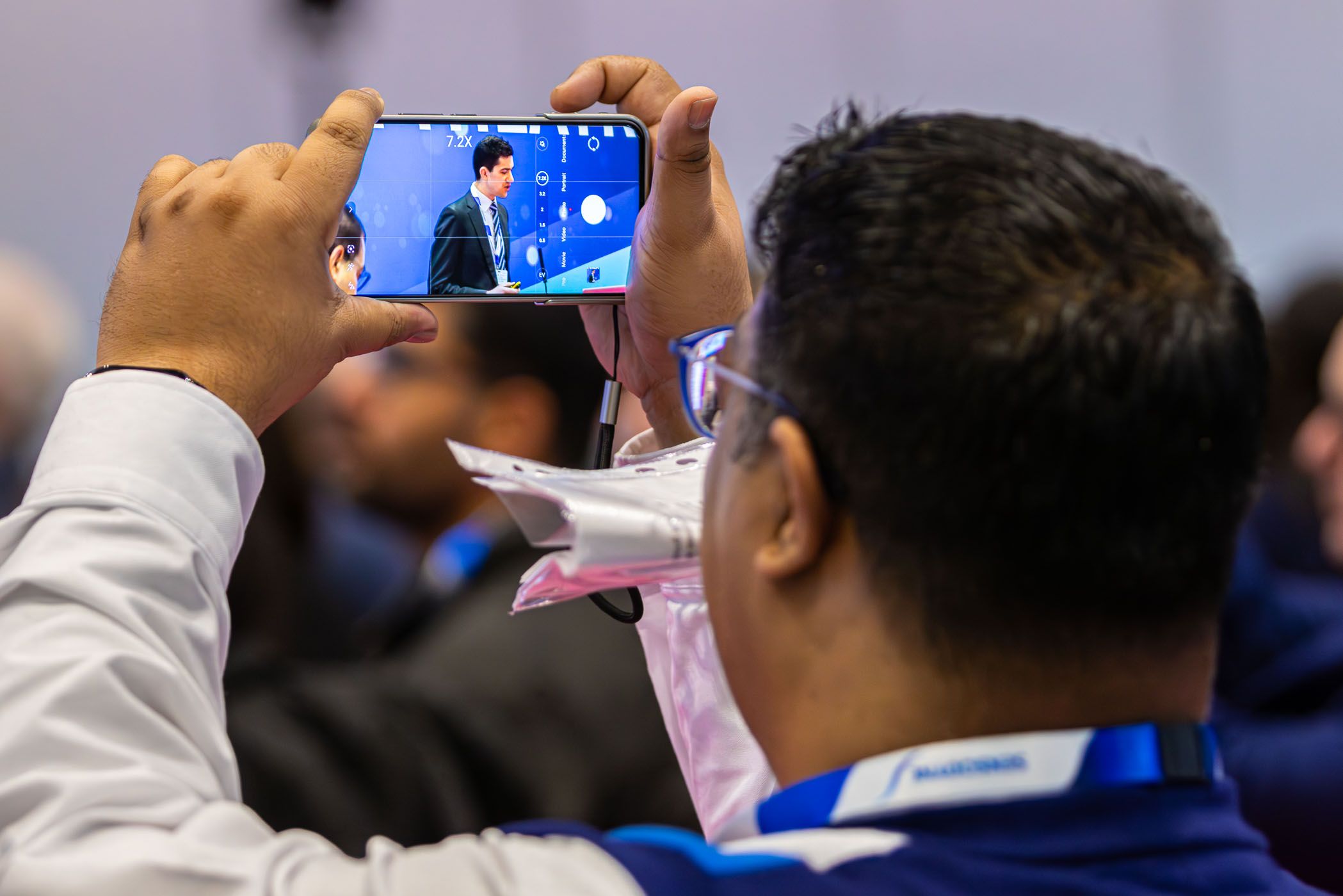 Man taking photo on his phone of conference session
