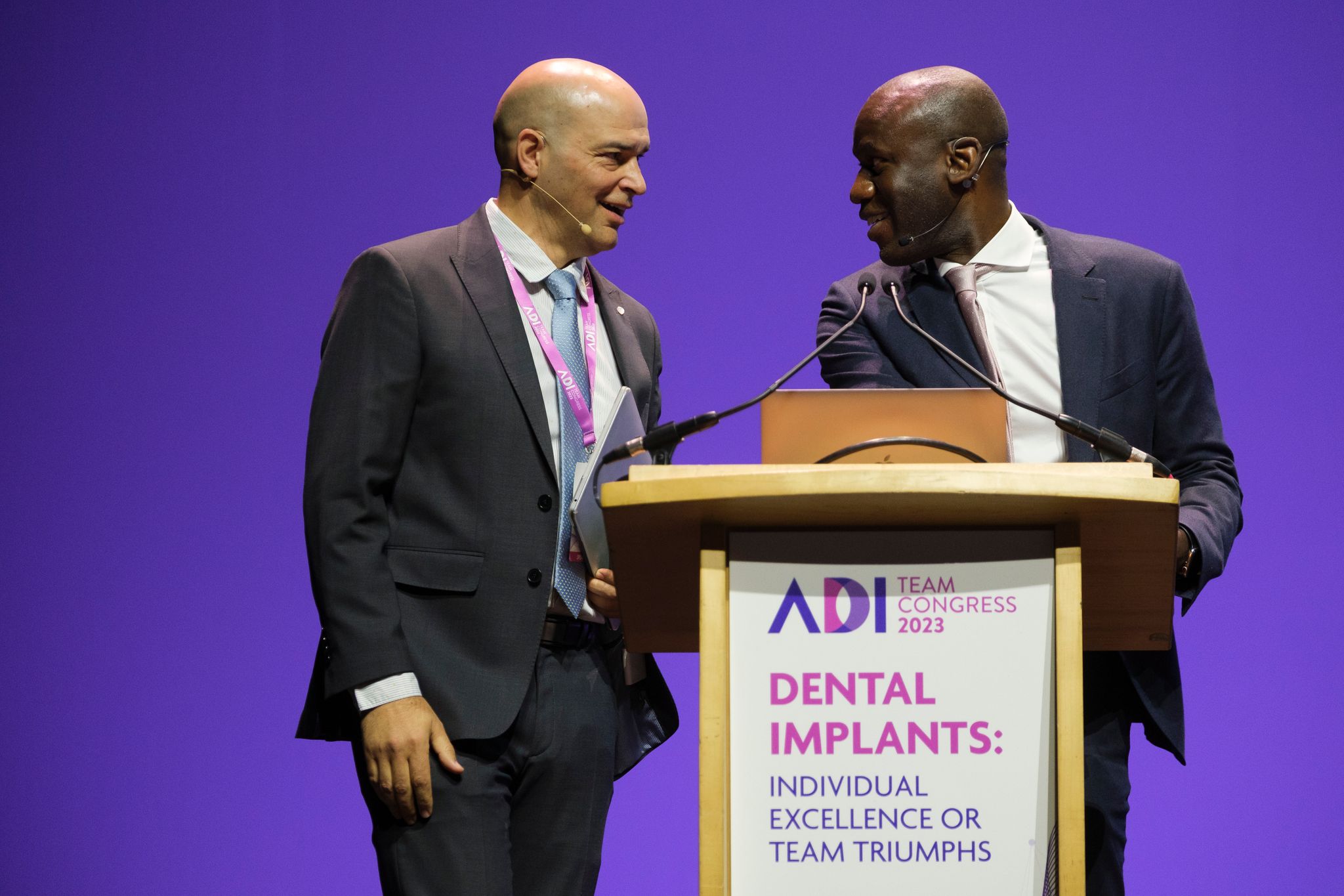 Two speakers from the Association of Dental Implantology (ADI) on stage at the ADI Implantology Zone & Theatre during the BDIA Dental Showcase.