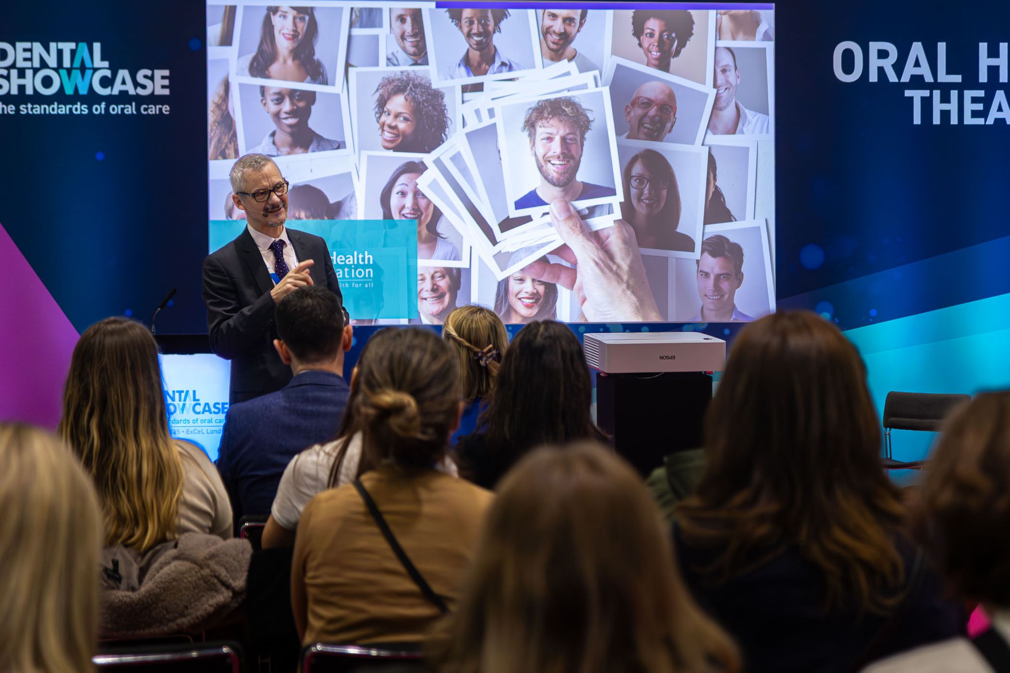 A young dental clinical professional addresses an audience of expert dentists and odontologists with a speech about dental compliance at the Oral Health Theatre during the BDIA Dental Showcase conference.