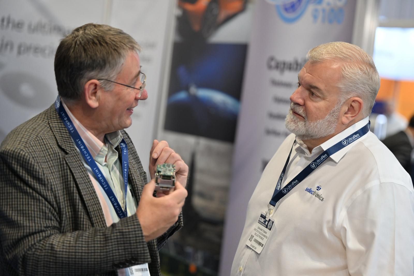 Two Subcon attendees discussing a manufacturing component on the show floor