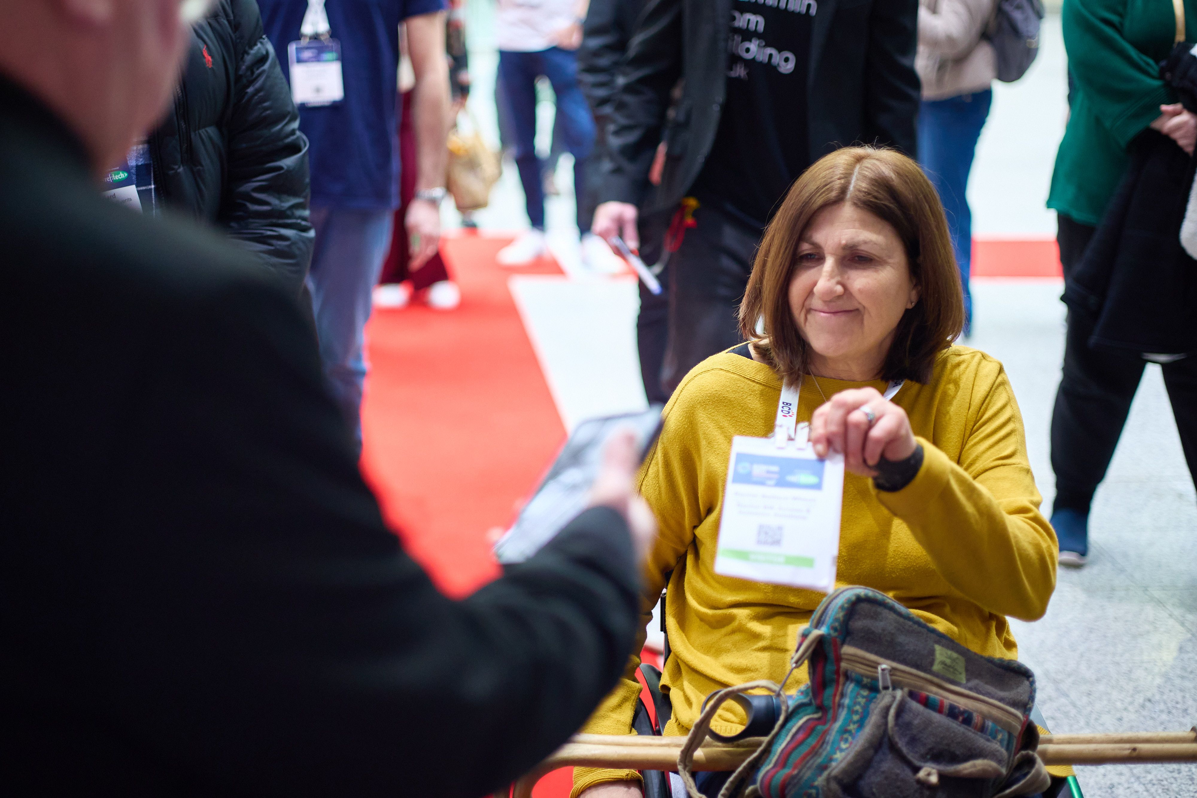 woman in wheelchair getting her badge scanned at registration