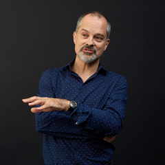 A man with grey hair and blue shirt