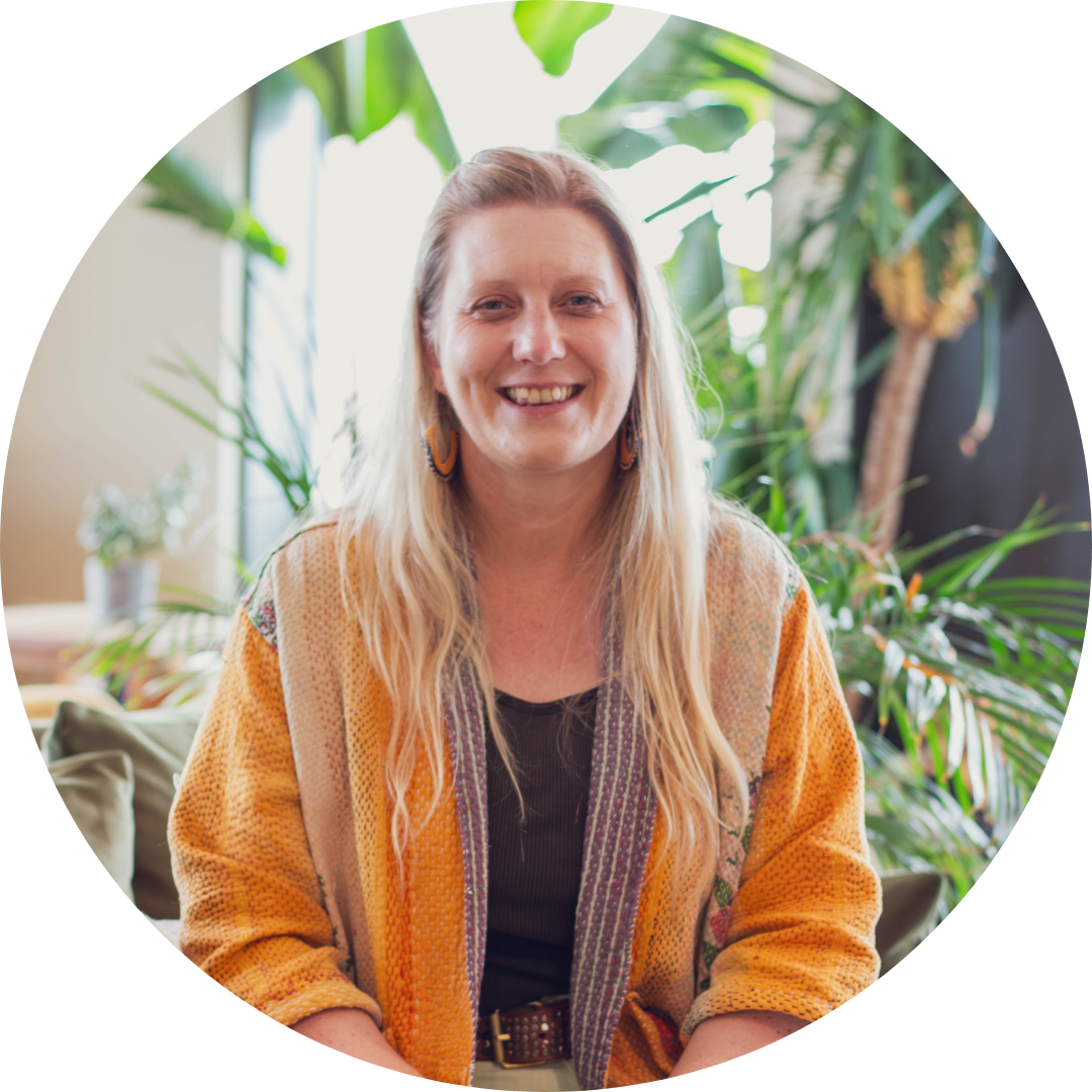 Profile Image of woman with blonde hair, wearing an orange cardigan