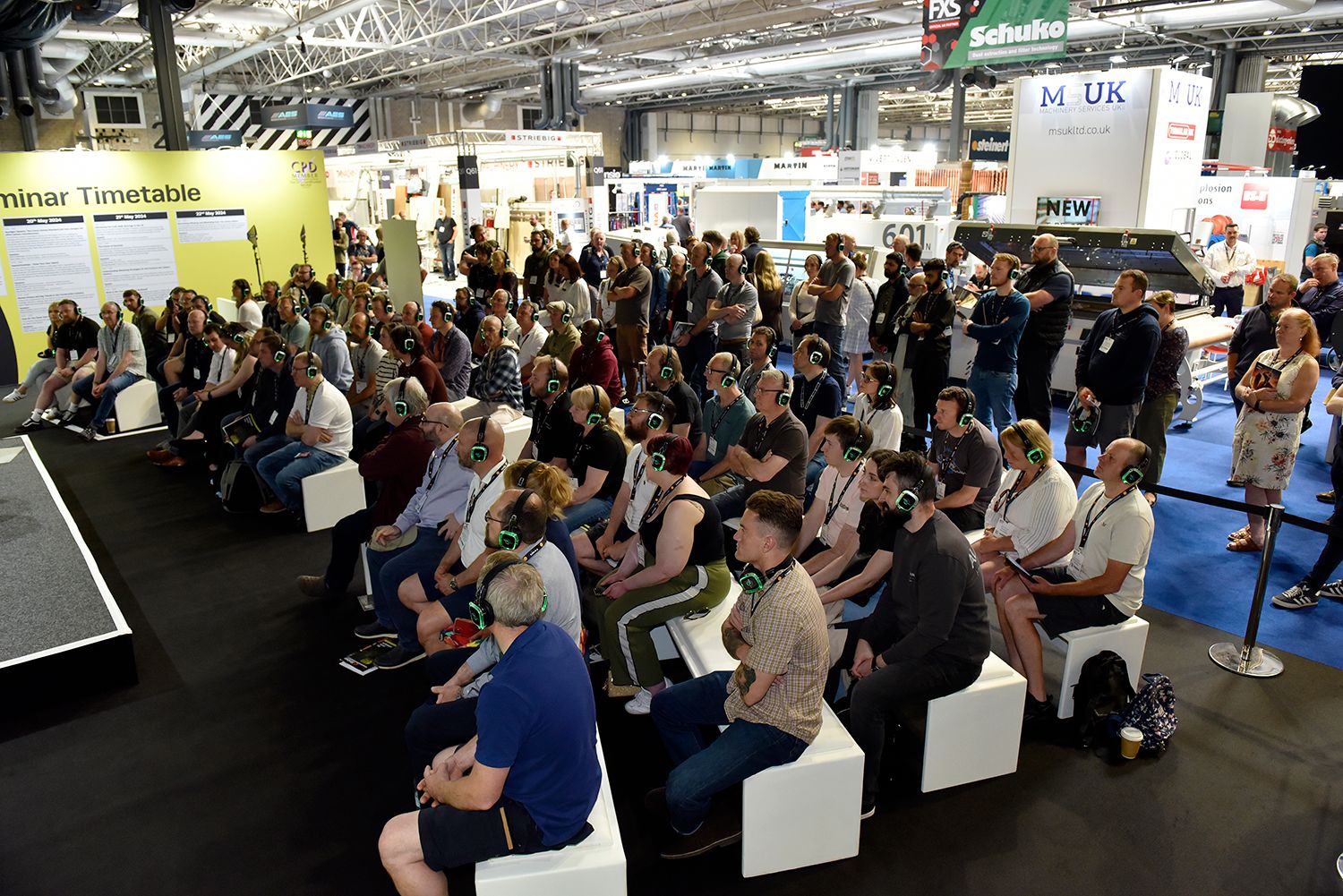 seminar stage with people watching wearing headphones
