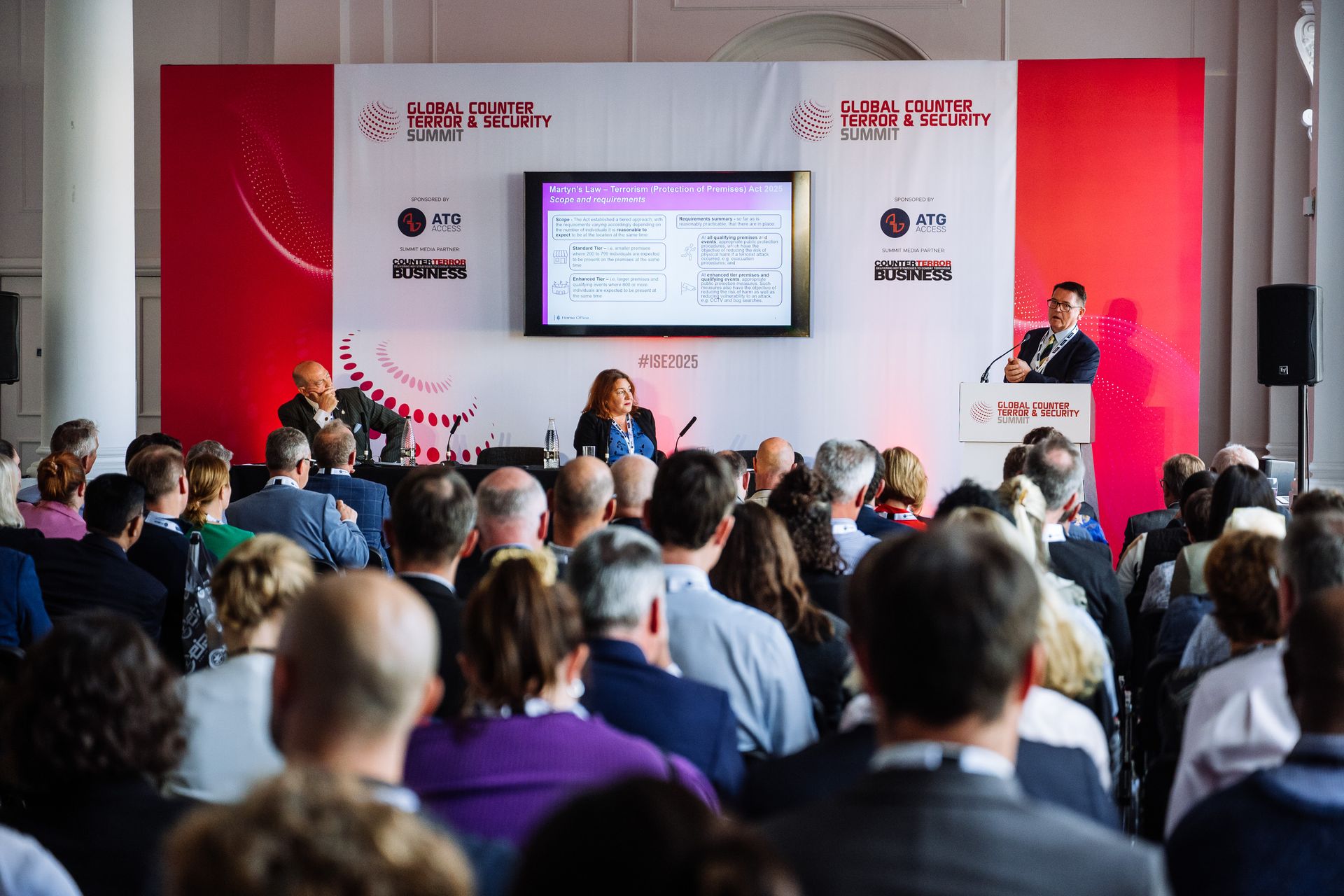 Shaun Hipgrave from the UK Home Office, and Michelle Russell from the SIA, speaking at International Security Expo 2025