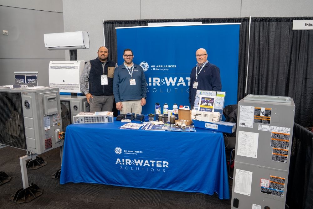 GE appliances smiling at their pip & drape stand, HVAC products on display.