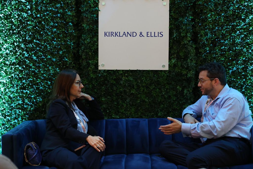 a woman and man sit in Kirkland and Ellis networking booth at NEXUS