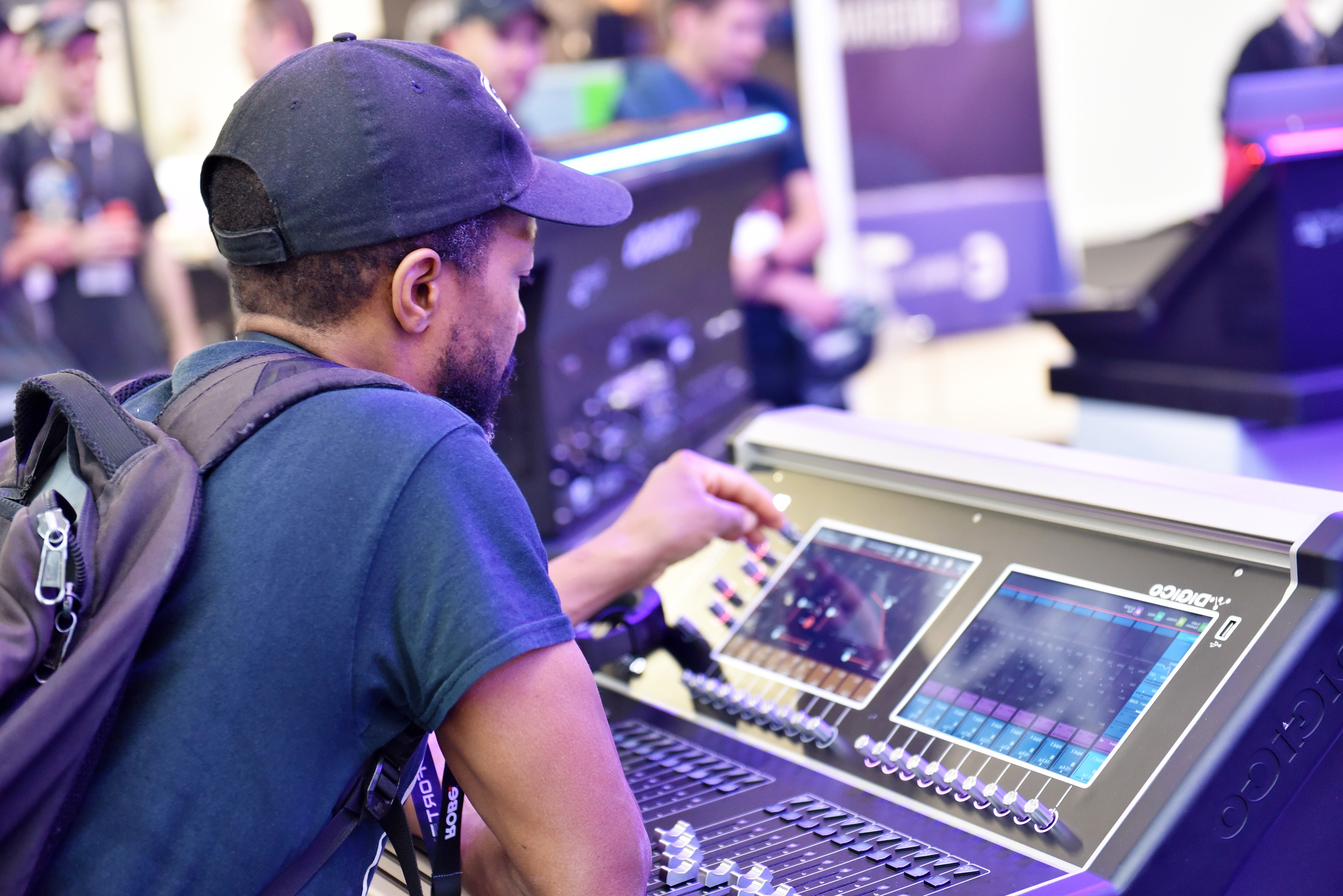 An entertainment technology professional trying out a sound desk at PLASA Show in 2022