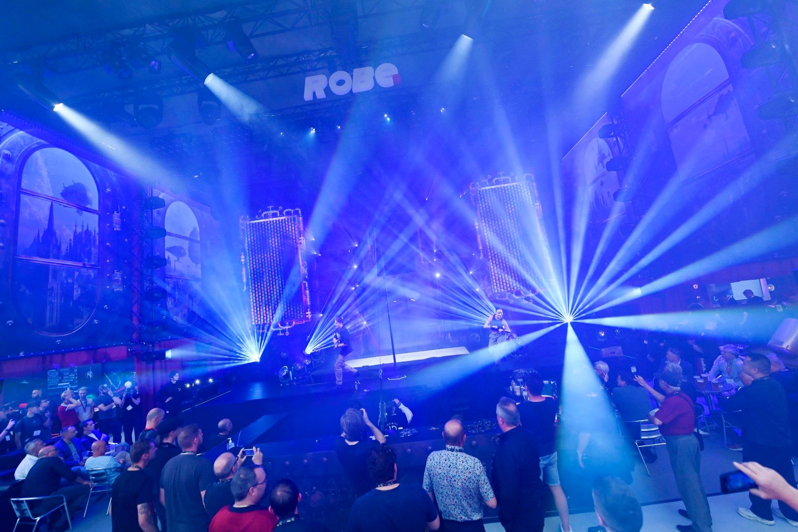 dancers performing on stage with blue light beams