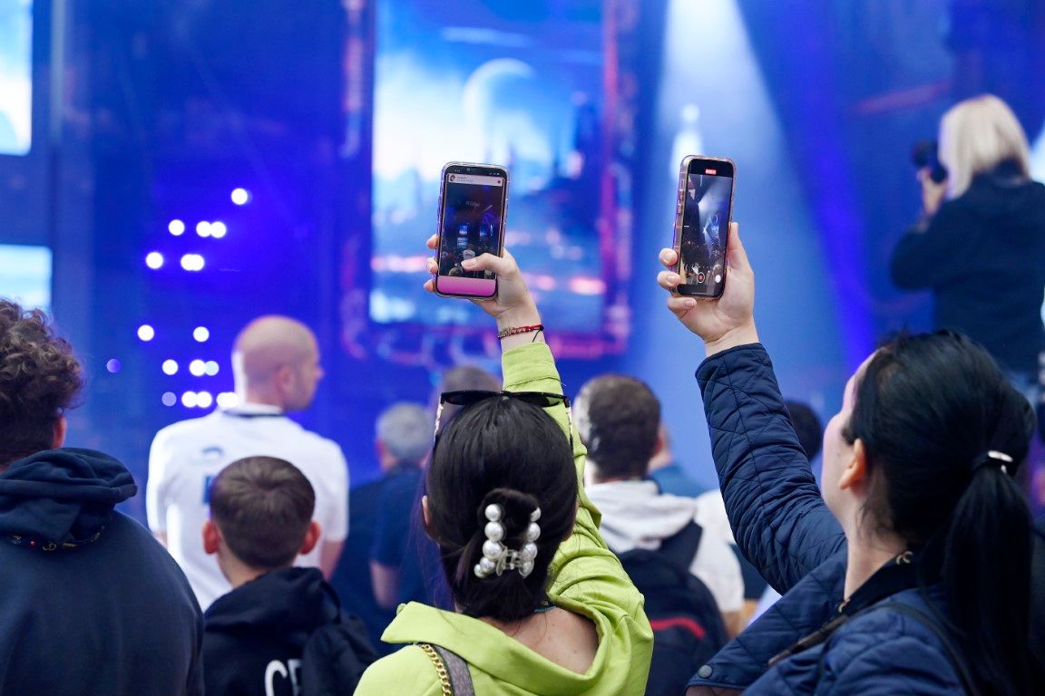 two female visitors taking pictures of the robe dance performance at plasa show