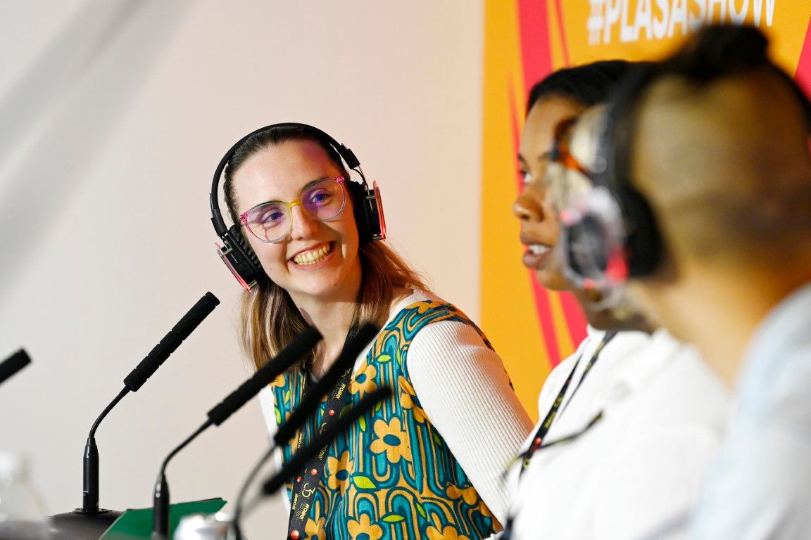 Woman smiling on a seminar panel at plasa show 2024