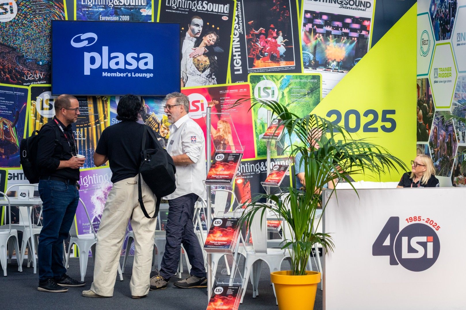 Visitors network at the PLASA Members’ Lounge during PLASA Show London 2025, with displays celebrating LSi Magazine’s 40th anniversary and past Lighting & Sound International covers.