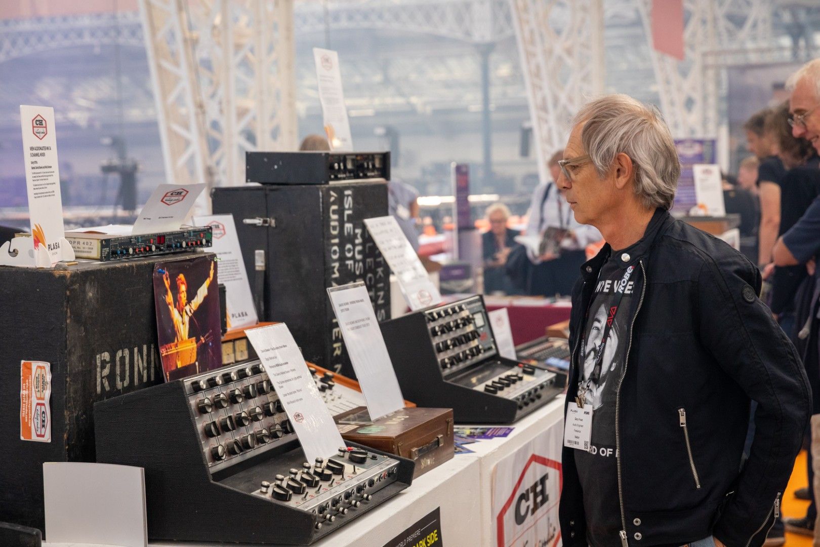 Visitor looks at vintage audio equipment on display at the Classic Gear Live exhibit during PLASA Show London 2025, featuring historic mixing consoles and amplifiers from CH Vintage Audio.