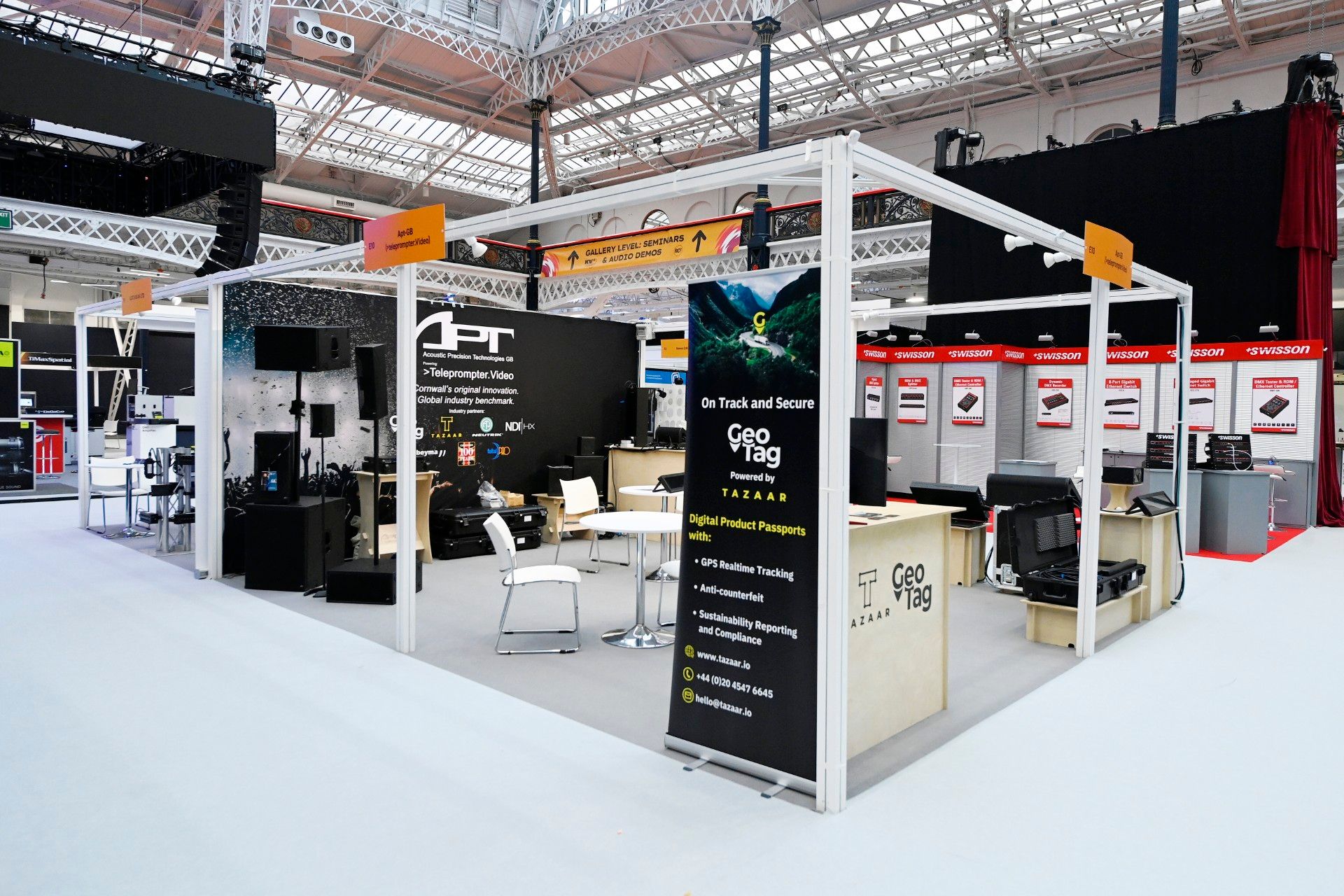 Exhibition stands for Acoustic Precision Technologies (APT) and GeoTag powered by Tazaar at PLASA Show London 2024, showcasing audio systems, digital tracking solutions and sustainability reporting tools inside Olympia.