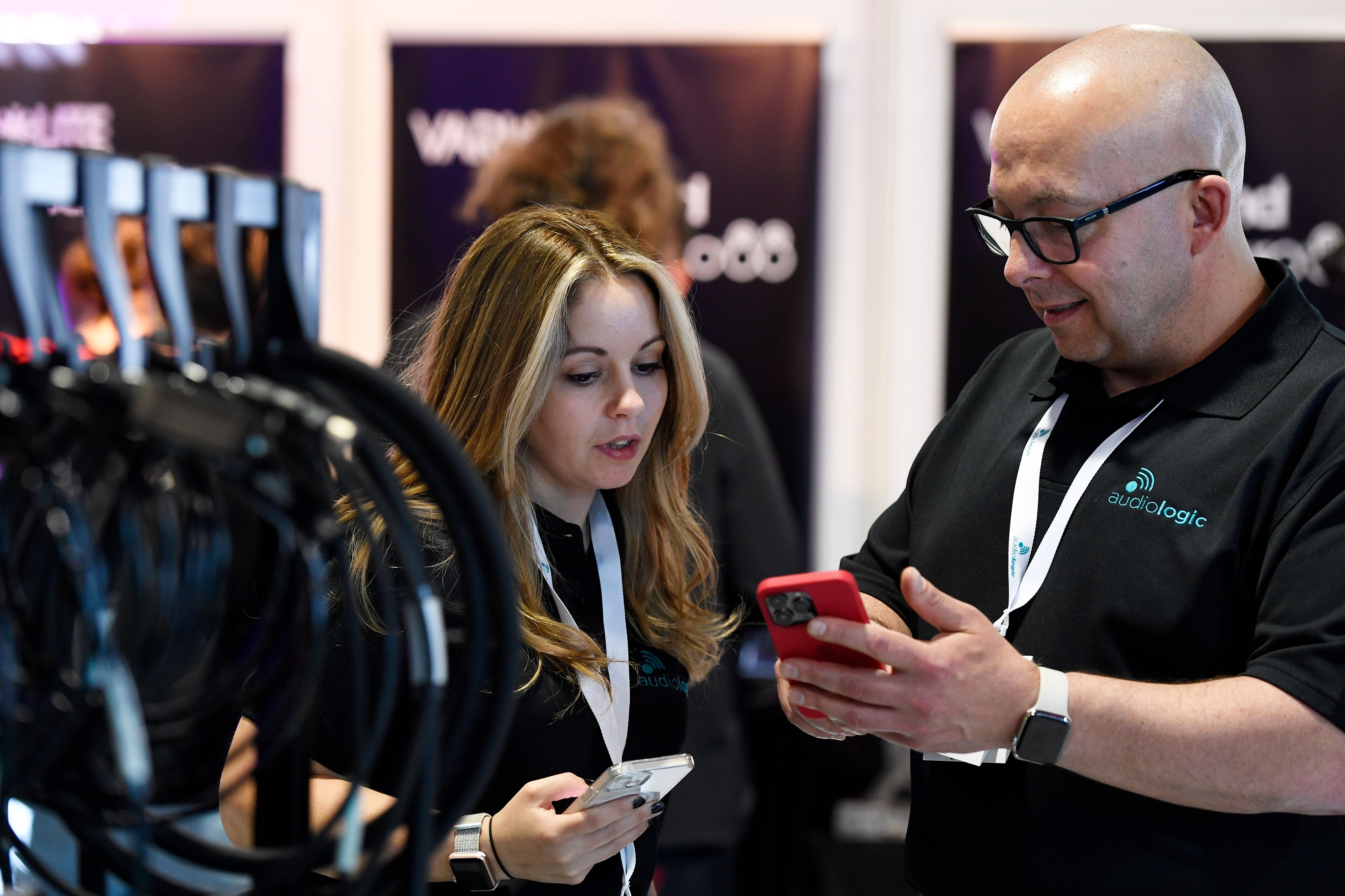 Audiologic employee talking to a young woman visitor at PLASA trade show in Leeds