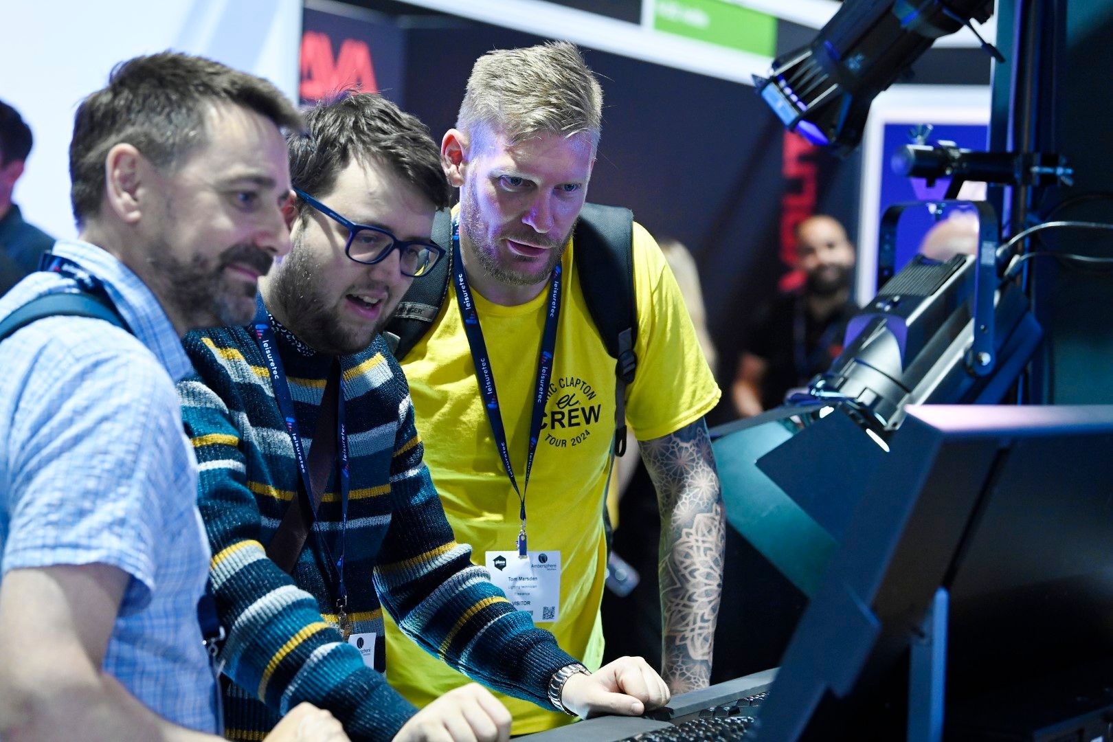 Three male visitors at light stand plasa focus leeds 2024