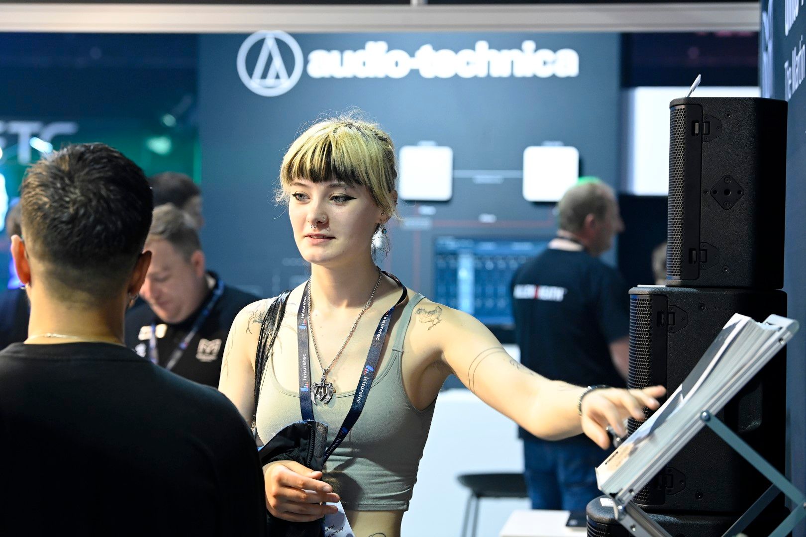 Young trendy female visitor talking to exhibitors at PLASA Focus Leeds 2024