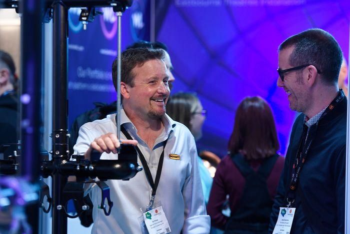 Exhibitor interacting with visitor at an entertainment technology trade show in Leeds UK