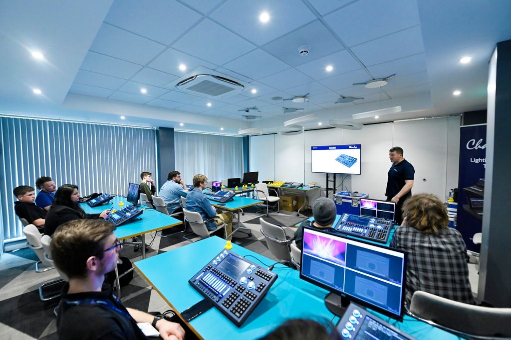 outdoor courtyard with bench seating and green umbrellas full of people chatting and walking around