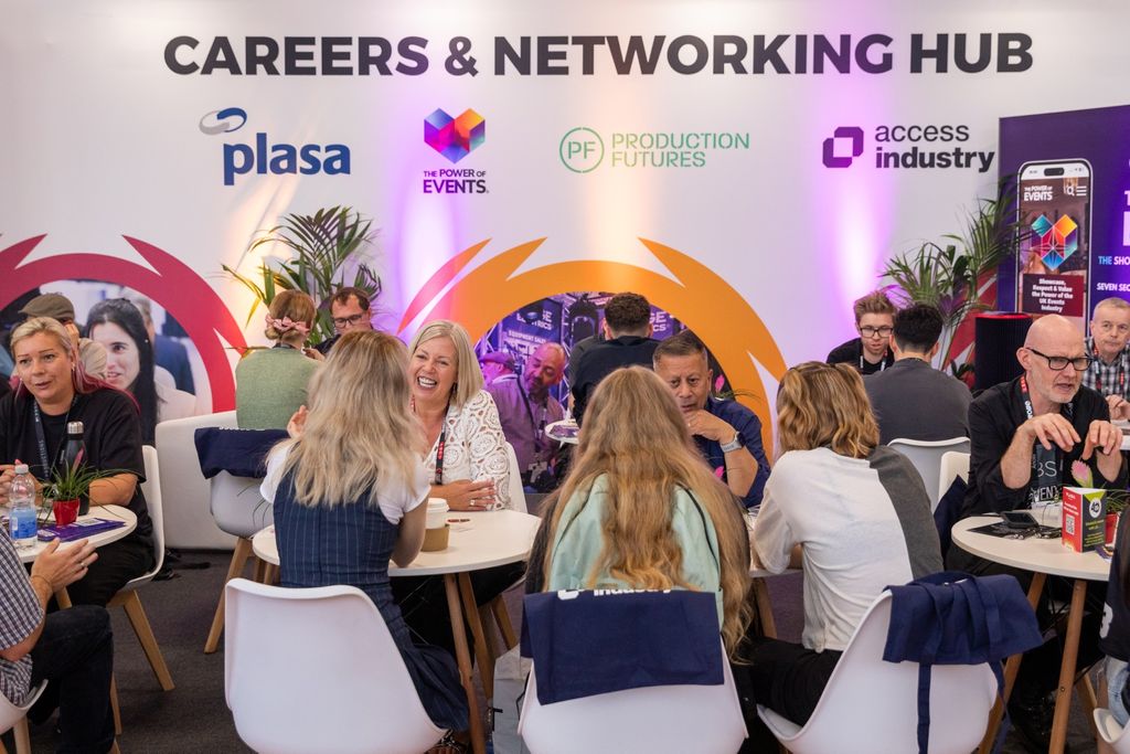 a group of professionals sitting and talking to students in a speed networking session at PLASA Show