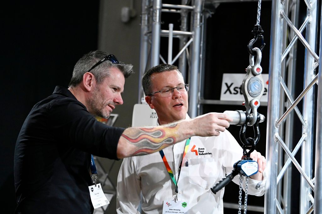 two men looking at stage equipment at PLASA Focus Leeds 2025